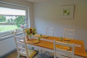 a dining room with a wooden table and chairs at Mee(h)r in Hasselberg