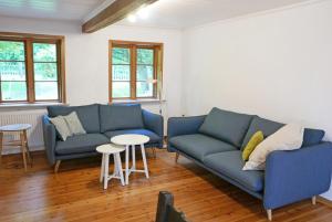 a living room with two blue couches and a table at Schöne von Angeln in Saustrup