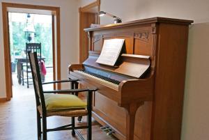 a piano sitting in a room with a chair at Schöne von Angeln in Saustrup