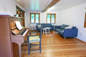 a living room with a piano and a blue couch at Schöne von Angeln in Saustrup +22 photos