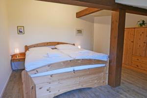 a bedroom with a wooden bed with white sheets at Schleimuschel in Kappeln