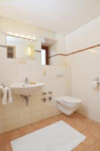 een witte badkamer met een wastafel en een toilet bij Gut Fallenstein in Bayerisch Gmain