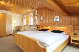 een groot bed in een kamer met houten wanden bij Gut Fallenstein in Bayerisch Gmain