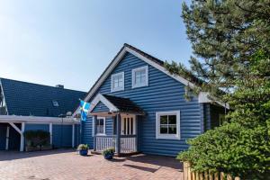 ein blaues Haus mit einer Einfahrt davor in der Unterkunft Ferienhaus Dat smuke Swedenhuus in Kappeln