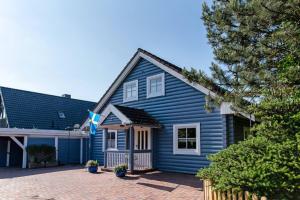a blue house with a driveway in front of it at Ferienhaus Dat smuke Swedenhuus in Kappeln