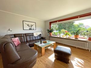 a living room with a leather couch and a table at Stadtoase in Süderbrarup