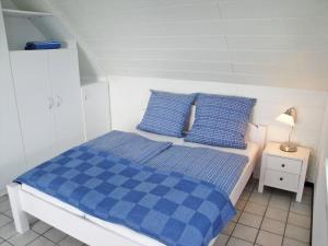 a bedroom with a blue and white bed with blue pillows at Vincent in Kappeln