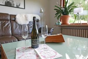 a bottle of wine sitting on a table with two wine glasses at Stadtoase in Süderbrarup