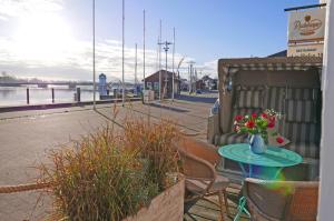 a table and chairs with a vase of flowers on a patio at Hafenheimat in Kappeln