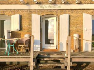 a porch with a table and chairs on a building at Hafenheimat in Kappeln