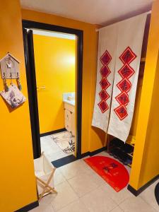 a bathroom with a yellow wall and a yellow door at Lu Yao Inn OP in Calgary