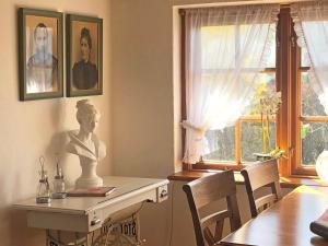 a room with a table with a bust on it and a window at Ferienhaus Rikate in Kappeln