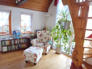 a living room with a chair and a book shelf at Ferienhaus Rikate in Kappeln