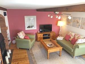 a living room with two couches and a tv at Ferienhaus Rikate in Kappeln
