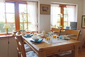 a dining room table with chairs and a wooden table with food at Ferienhaus Rikate in Kappeln