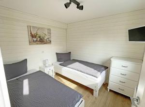 a bedroom with two beds and a dresser at Schlei-Idyll in Kappeln