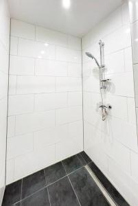 uma casa de banho com um chuveiro com azulejos brancos em Wohnung alleinige Nutzung 40m² 4 Schlafplätze Wiesbaden em Wiesbaden
