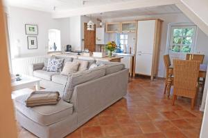 a living room with a couch and a kitchen at Lille Skov in Rabenkirchen +11 photos