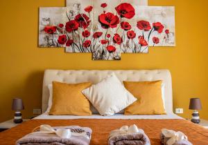 a bedroom with red poppies paintings on the wall at Blu Mare Lampedusa Bed And Breakfast in Lampedusa