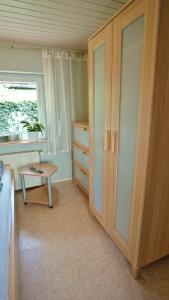 um quarto com um armário, uma mesa e uma janela em Geel Hus em Brodersby