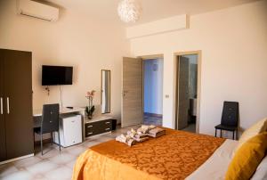 a bedroom with a bed and a desk and a television at Blu Mare Lampedusa Bed And Breakfast in Lampedusa