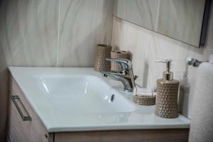 a white sink in a bathroom with a mirror at Blu Mare Lampedusa Bed And Breakfast in Lampedusa