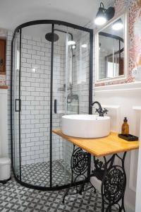 uma casa de banho com um lavatório e um chuveiro em EgerCottages - Bikavér Cottage em Eger