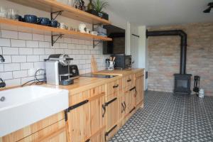 uma cozinha com um lavatório e um fogão em EgerCottages - Bikavér Cottage em Eger