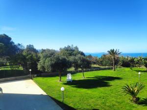 a park with a bench in the grass at Campofelice Holidays in Campofelice di Roccella