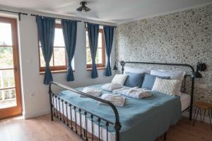 1 dormitorio con cama azul y cortinas azules en EgerCottages - Bikavér Cottage en Eger