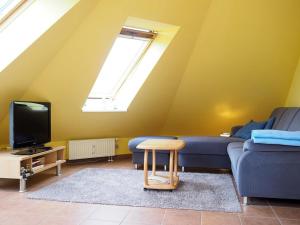 プレローにあるHaus am Brunnen Apartment 50のリビングルーム(青いソファ、テレビ付)