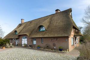 a large brick house with a thatched roof at Deichmuschel in Wöhrden