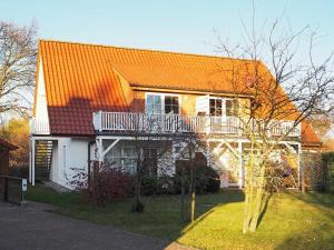 ein Haus mit einem orangenen Dach und einem Balkon in der Unterkunft Apartments Haus an der Stems 30 & 31 in Prerow