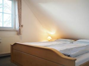 ein großes Bett in einem Zimmer mit Fenster in der Unterkunft Apartments Haus an der Stems 30 & 31 in Prerow