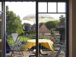 a table and chairs and an umbrella on a patio at Haus Komoran Wohnung 3 in Prerow