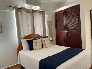 1 dormitorio con 1 cama de color azul y blanco en Hotel Montesilva, en San Felipe de Puerto Plata
