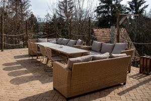 a patio with a wooden table and wicker chairs at EgerCottages - Bikavér Cottage in Eger