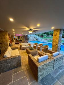 una sala de estar con sofás y sillas y una piscina en Lujosa Casa Campestre 5 estrellas a 18 min de Cali, en Cali