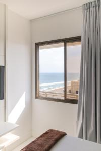 1 dormitorio con ventana y vistas al océano en Apartment Ocean View II, en Río de Janeiro