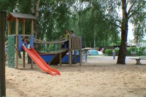 un parque infantil con gente jugando en un tobogán en "OSLO" - Haus am See mit Sandstrand nahe Rhein-Main und Spessart, en Kahl am Main