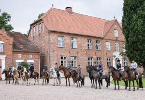 a group of people on horses in front of a building at FerienGut Gaarz - Kavaliershaus 17 in Göhl