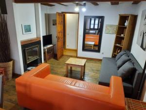 ein Wohnzimmer mit einem orangenen Sofa und einem Kamin in der Unterkunft Apartamento centro Benasque in Benasque