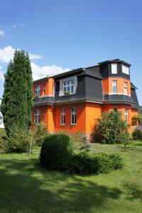 uma grande casa laranja com um telhado preto em Großzügige Fewo mit Terrasse, Strandkorb em Bansin