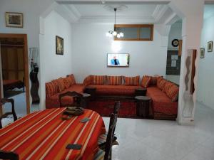 ein Wohnzimmer mit einem Sofa und einem Tisch in der Unterkunft Duplex Fes Médina - Friends Family Friendly in Fès