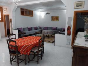ein Wohnzimmer mit einem Tisch und einem Sofa in der Unterkunft Duplex Fes Médina - Friends Family Friendly in Fès