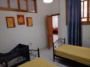 1 dormitorio con 2 camas, ventana y puerta en Duplex Fes Médina - Friends Family Friendly en Fez