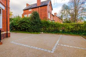 Un estacionamiento vacío frente a un edificio de ladrillos en Hilltop Serviced Apartments - Stockport, en Stockport