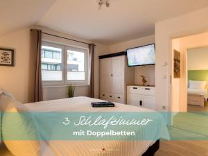 ein Schlafzimmer mit einem Bett und einem TV in der Unterkunft Ferienhaus StrandLiebe in Olpenitz