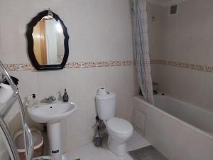 La salle de bains est pourvue de toilettes, d'un lavabo et d'un miroir. dans l'établissement Duplex Old Médina, à Fès