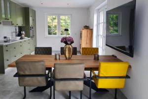 uma sala de jantar com uma mesa de madeira e cadeiras amarelas em Muehlenblick 3 - Traumferien in Hage em Hage